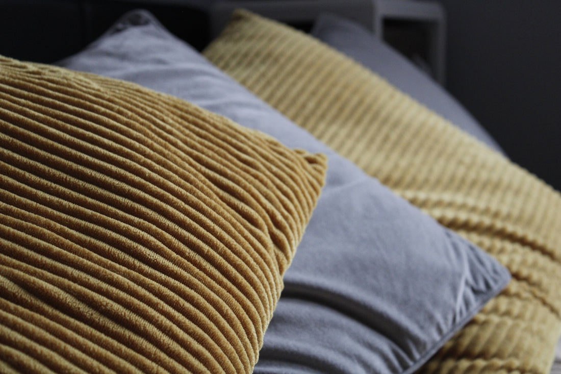 yellow throw pillow on blue textile