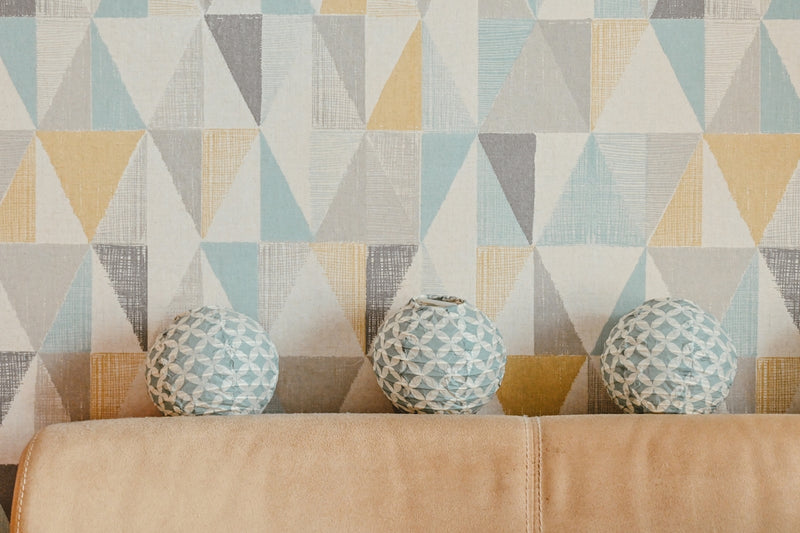 three vases sitting on a couch in front of a wall