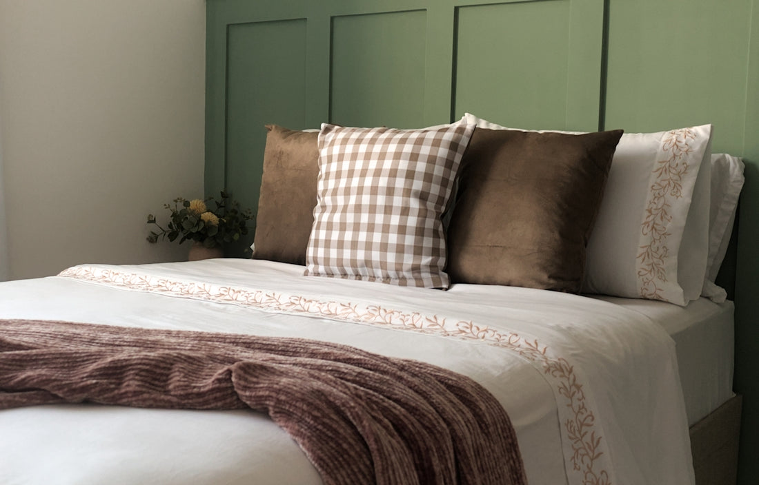 A bed with a blanket and pillows on top of it