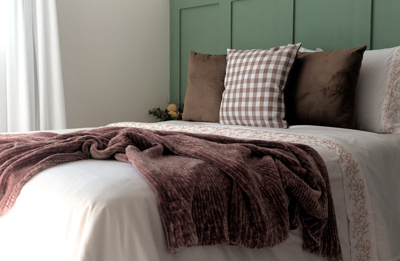 A bed with a blanket and pillows on top of it