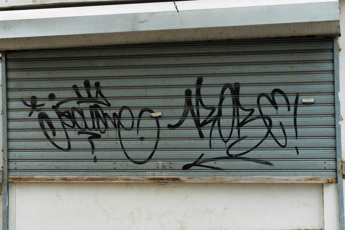 Graffiti covers a closed metal garage door.
