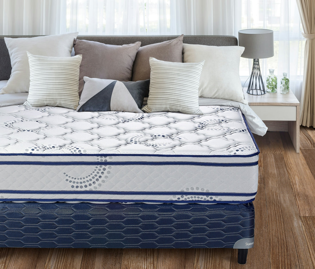 A neatly made bed with a patterned mattress and pillows.